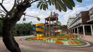 Un parque acuático con una zona de juegos colorida, que incluye toboganes y una piscina.