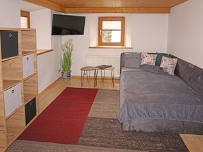Relax in a serene bedroom with a comfortable bed, a small table, and a potted plant.