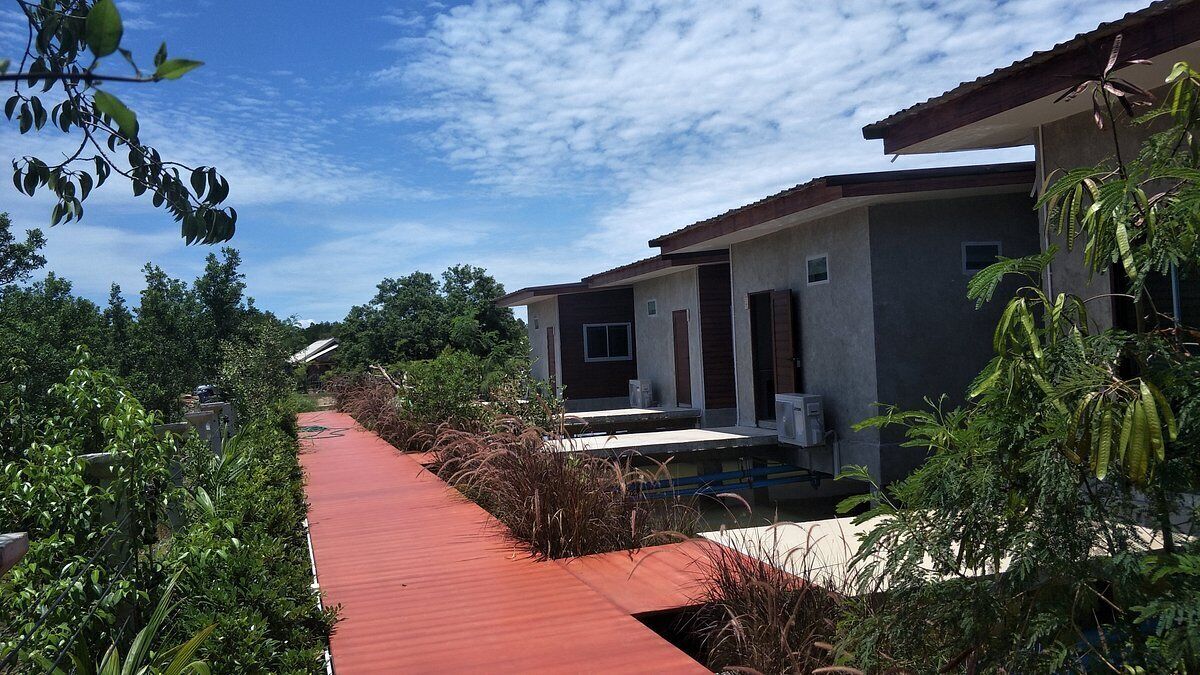 A modern building with a red pathway leading to the entrance.