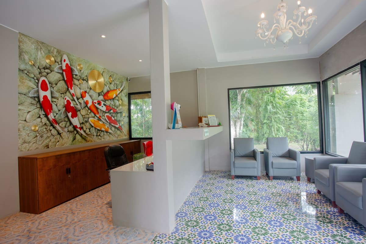 A modern reception area with a stone wall mural, a wooden reception desk, and a seating area with grey sofas.