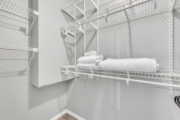 A white metal shelving unit with folded white towels. - Pet-Friendly 5BR Getaway near Lake Keowee (Seneca)