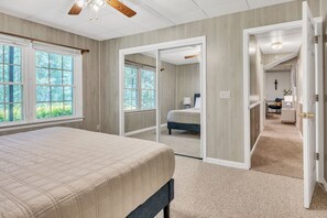 Un dormitorio con una cama grande, un vestidor y vistas al exterior.