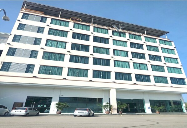 A multi-story hotel with a modern facade, large windows, and a flat roof.