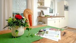 Una cocina moderna con armarios blancos, un microondas y un ventanal pequeño.