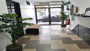 Een receptiegedeelte met een receptiebalie, een bank en potplanten.