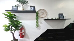Een modern interieur met een zwarte trap, witte muren en een brandblusser aan de muur.