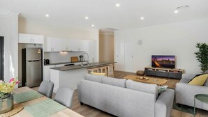 Een modern appartement met keuken, eethoek en woonkamer.