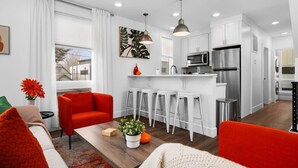 Eine moderne Wohnung mit Wohnzimmer, Küche und Essbereich.