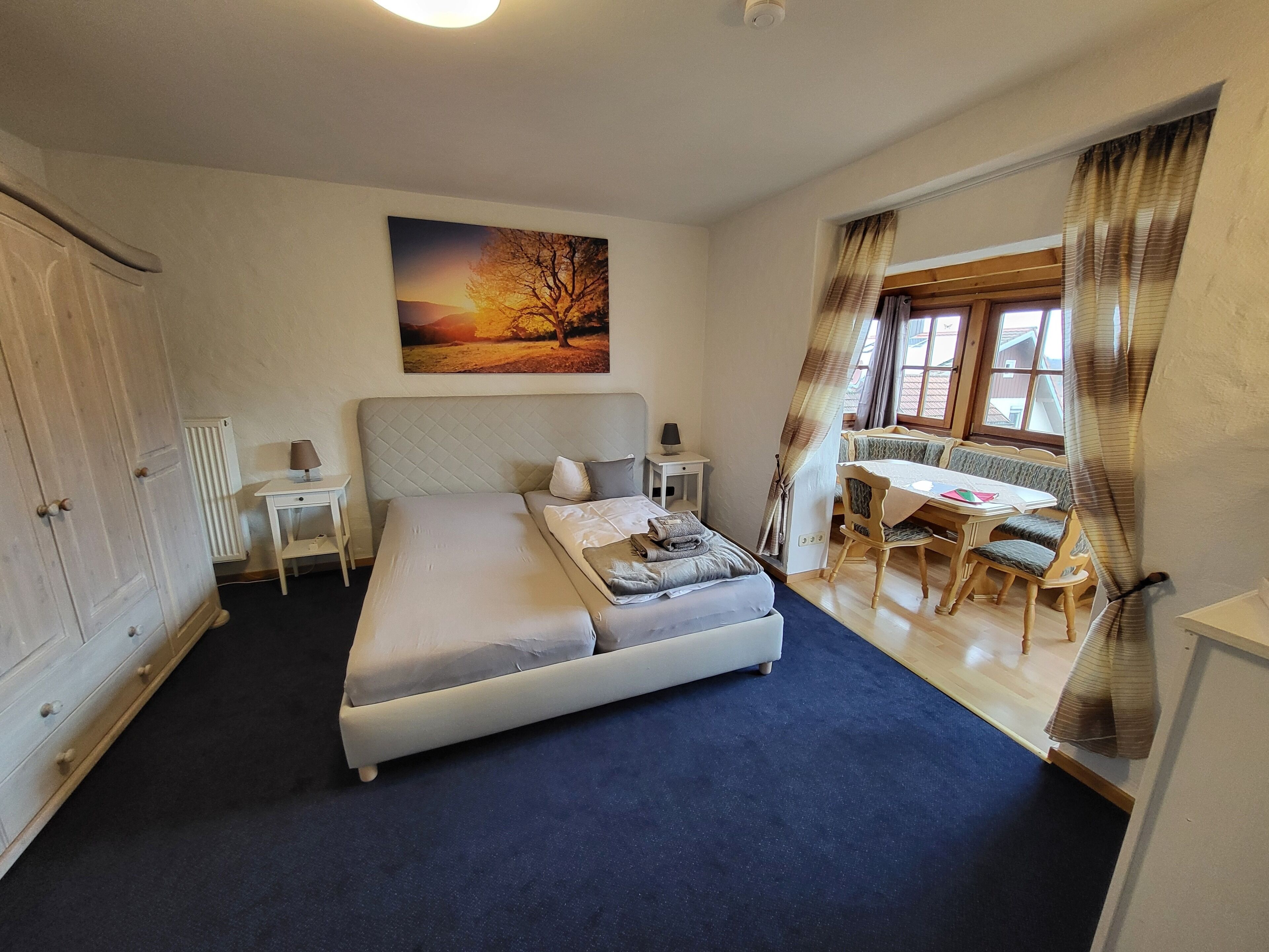 A bedroom with a bed, a desk, and a chair.