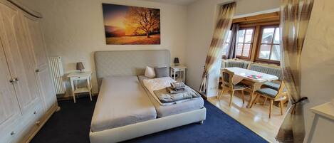 A bedroom with a bed, a desk, and a chair.