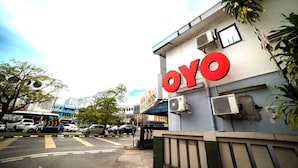 Ein Gebäude mit einem großen, roten „OYO“-Schild, das ein Hotel oder eine andere Geschäftsstelle kennzeichnet.
