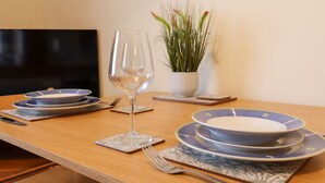 A dining table set with plates, a glass of water, and cutlery. - The View (Faversham)