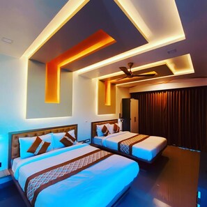 A modern hotel room with two beds, a ceiling fan, and a dark curtain backdrop. - Hollywood Palace Resort (Mahabaleshwar)
