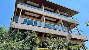A multi-story building with balconies, large windows, and a flat roof. - Hollywood Palace Resort (Mahabaleshwar)