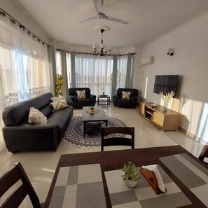 Relax in this stylish living room with a sofa, coffee table, and dining area.