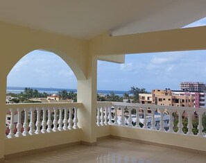 Ein Balkon mit Blick auf das Meer und die Gebäude.