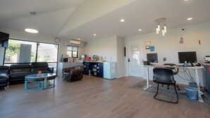 Amplia sala de estar con cocina, comedor y zona de estar con mesa de centro y sofás.