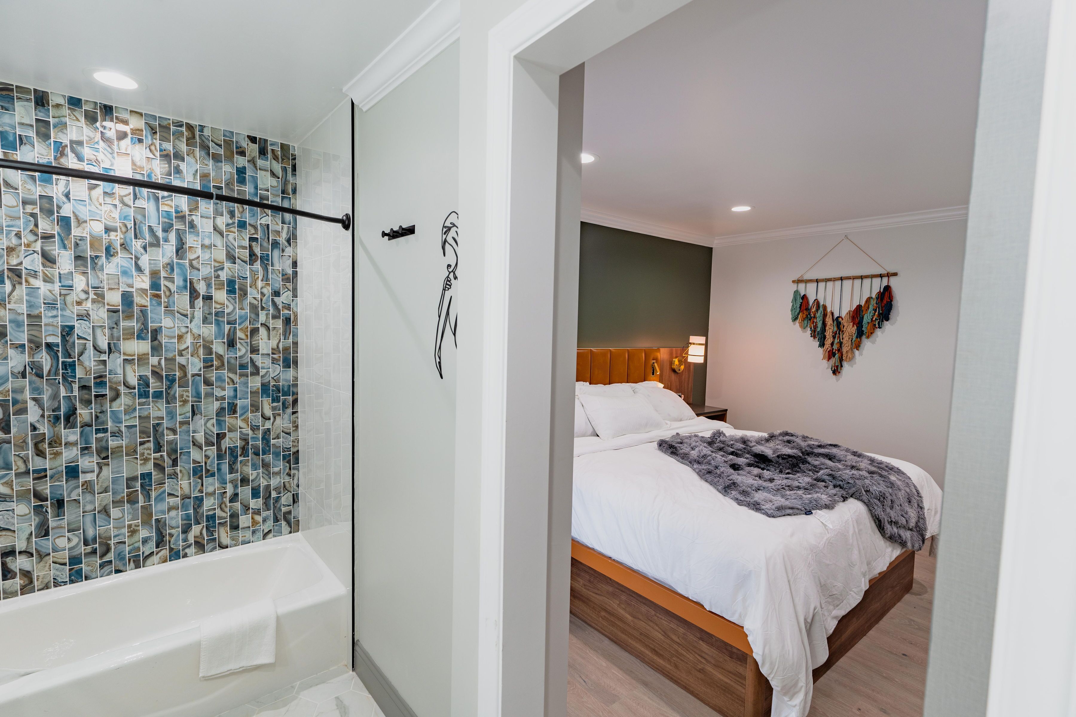 A modern bathroom with a mosaic tile shower wall and a separate shower area.