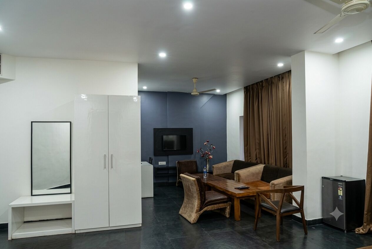 A modern living room with a dining area, a flat-screen TV, and a ceiling fan.