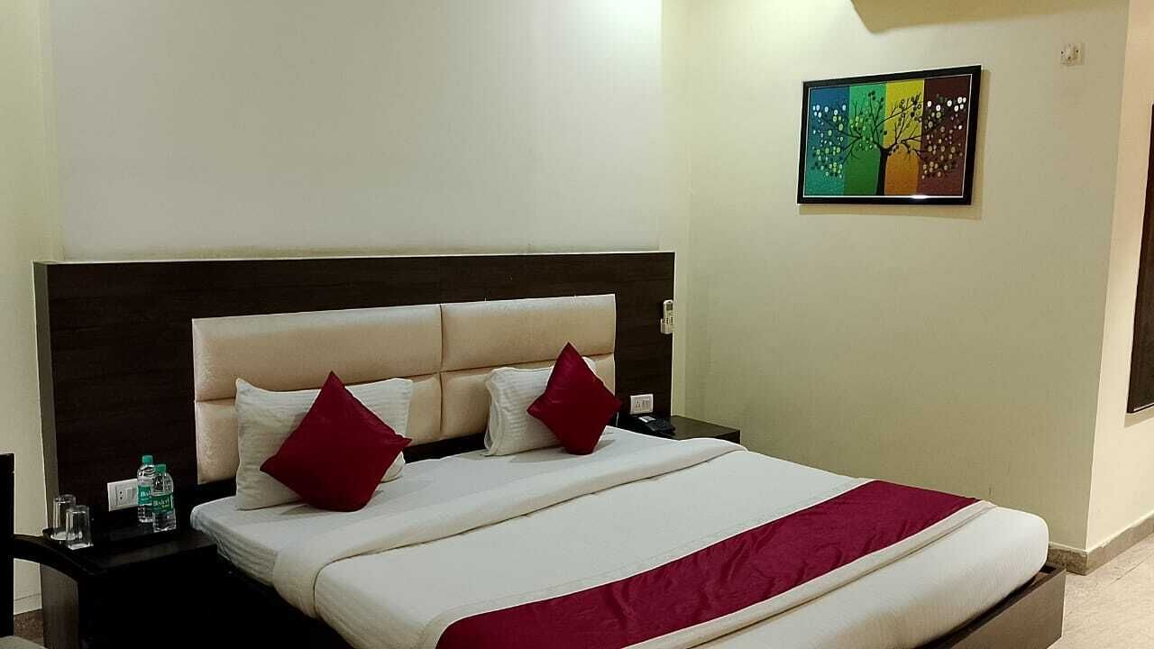 A bed with a headboard, two pillows, a bedside table, and a wall-mounted picture.