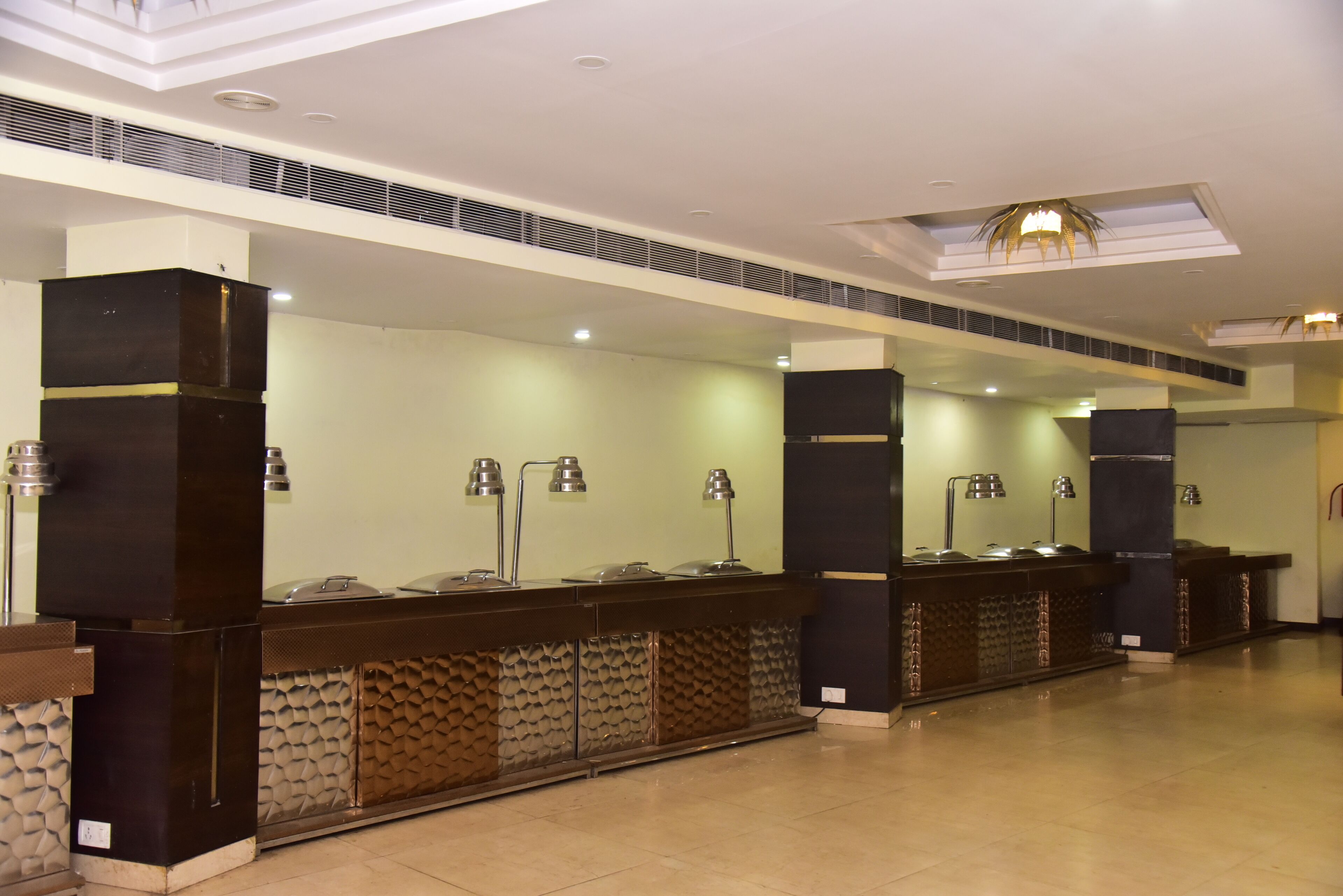 A reception area with a counter, lamps, and a ceiling with a skylight.