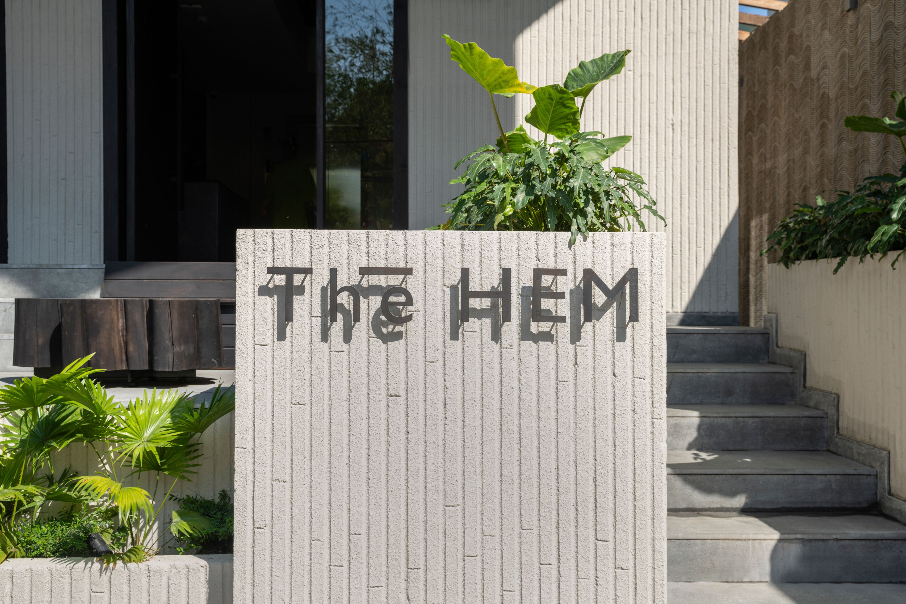 Une entrée d’immeuble avec une enseigne indiquant « THE HEM » et un escalier menant à l’étage supérieur.
