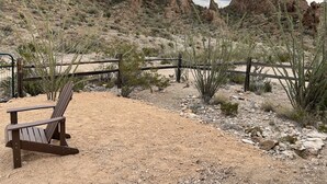 Un paysage désertique avec une clôture en bois, un terrain rocheux et une végétation clairsemée.