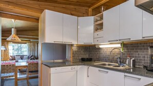 Una cocina moderna con armarios blancos, encimera de granito y pileta de acero inoxidable.