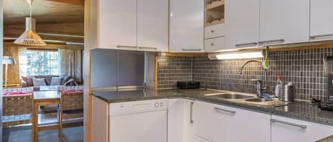 A modern kitchen with white cabinets, a granite countertop, and a tiled backsplash.