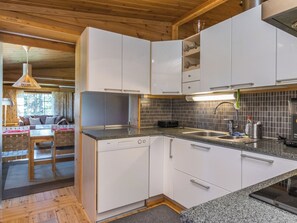 A modern kitchen with white cabinets, a granite countertop, and a tiled backsplash.