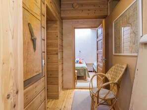 A wooden interior with a bed, a chair, and a map on the wall.