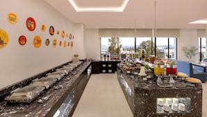 Um buffet de café da manhã moderno com diversas opções de alimentos e um balcão extenso.
