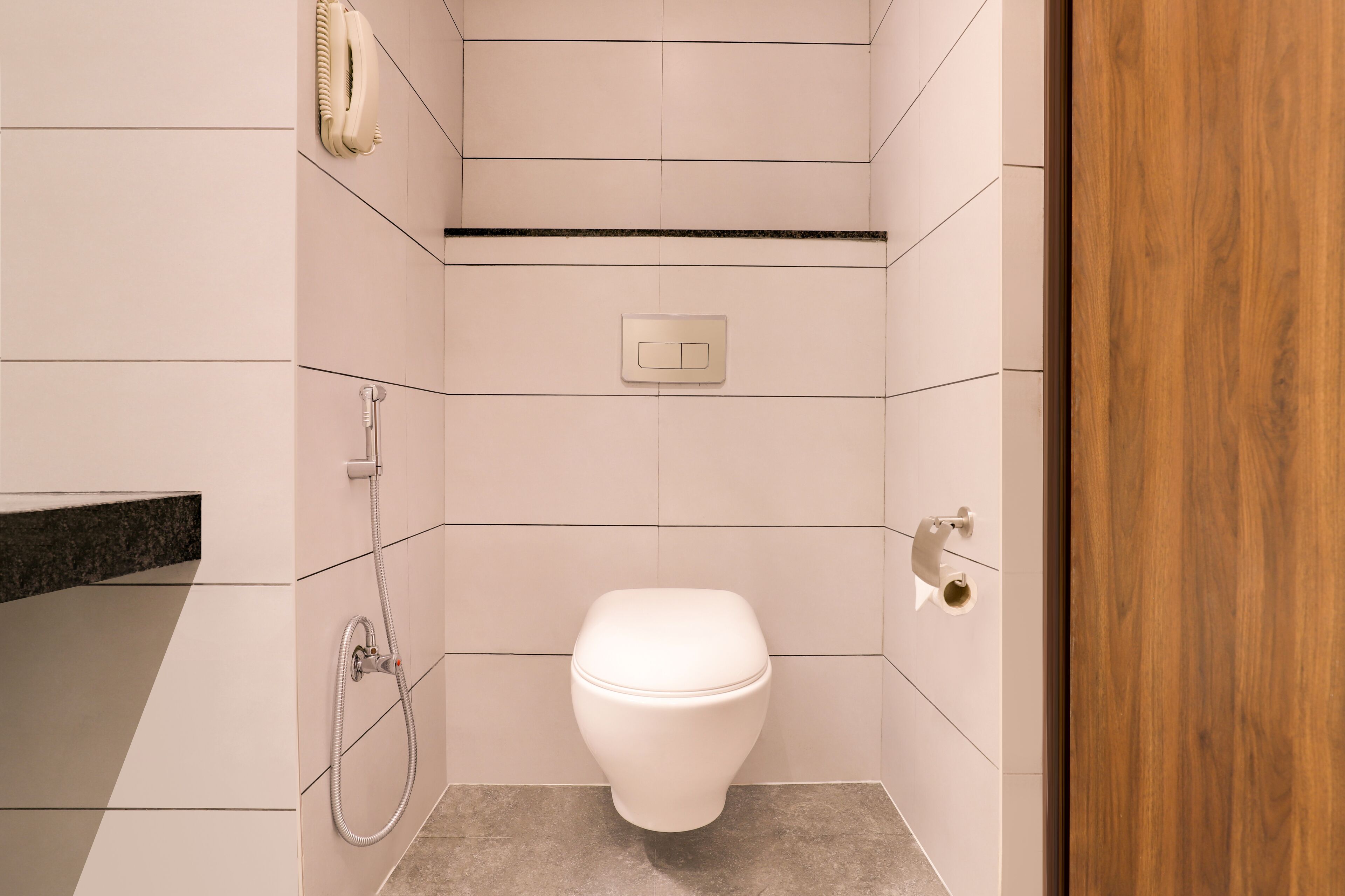 Ein modernes Badezimmer mit Toilette, Dusche und Handtuchhalter.