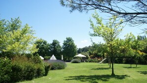 A well-maintained garden with a grassy lawn, a play area, and a white gazebo. - Apartment in Montone with Pool & Garden (Montone - Umbertide (pg))