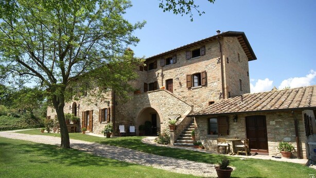 A stone building with a courtyard, a staircase leading to an upper level, and outdoor seating. - Apartment in Montone with Pool & Garden (Montone - Umbertide (pg))
