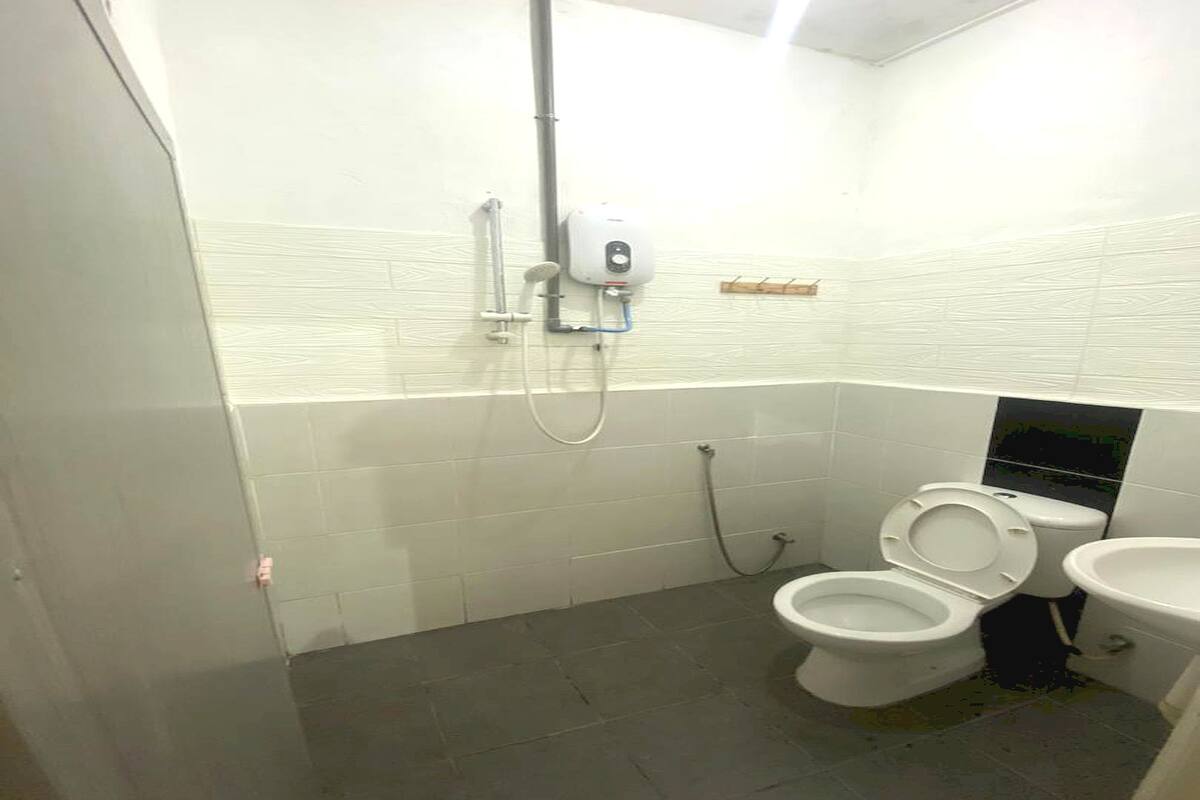 Un baño con inodoro, bidé y secamanos automático.