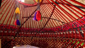 A traditional yurt with a white table and benches, decorated with colorful tassels. - Kel-Suu At-Bashy (Kel Suu)