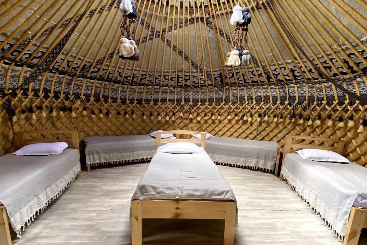 A circular room with a central bed and two smaller beds along the walls.