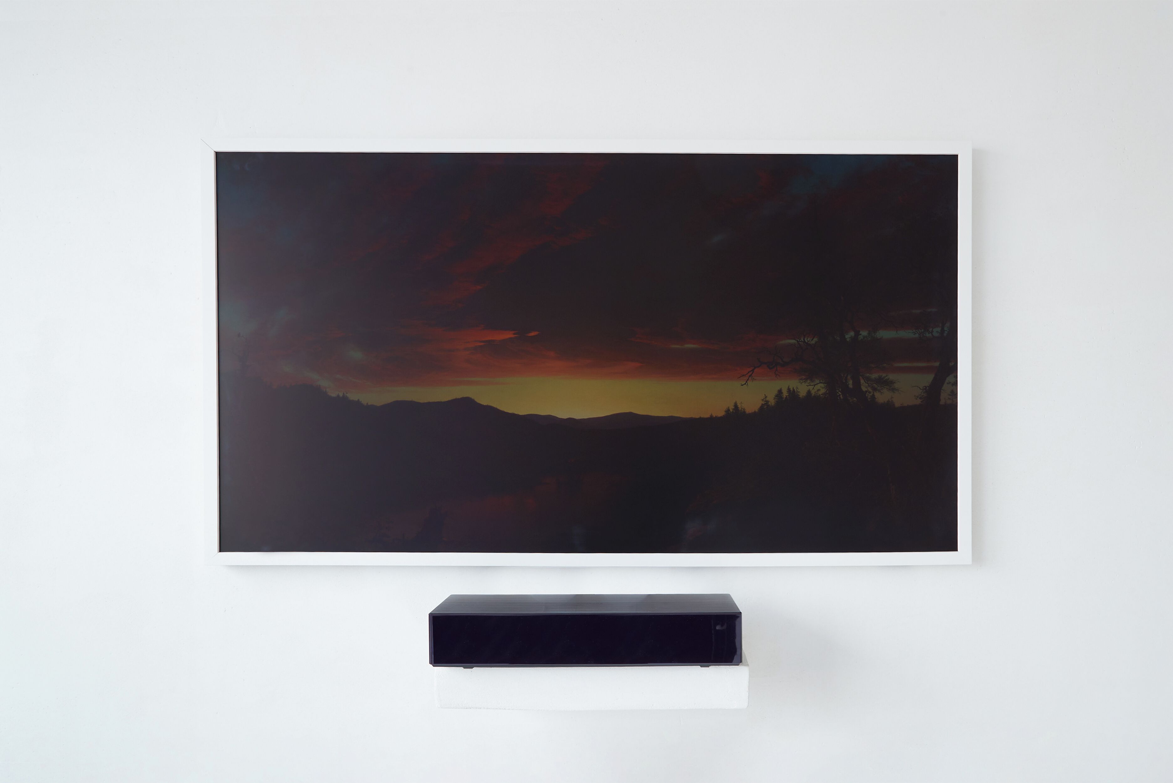 A flat-screen TV mounted on a white wall, with a landscape painting above it.