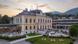 Un bâtiment historique doté d’une cour intérieure, de places assises en plein air et offrant une vue sur les montagnes.