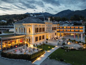 A hotel with a classical facade, outdoor seating area, and a well-maintained garden. - Villa Seilern Vital Resort (Bad Ischl)