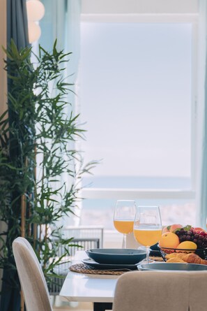 A dining table with two glasses of orange juice, a bowl of fruit, and a croissant. - Sea view gem in Torremolinos REF039 (Torremolinos)