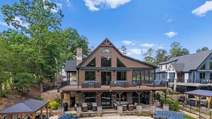 A large house with a pool, outdoor furniture, and a covered patio area.