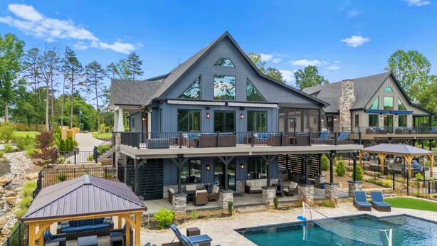 A large house with a pool, outdoor seating, and a covered patio. - Luxe Lakefront Lodge w/ Pool, Hot Tub, Theater & Private Dock | Sleeps 21 (Sherrills Ford)