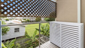 A balcony with a lattice screen, a white radiator, and a view of a residential area. - 600m to esplanade - Spacious + Everything you need (Pialba)