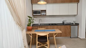 A compact kitchen with wooden cabinets, a microwave, and a small sink.