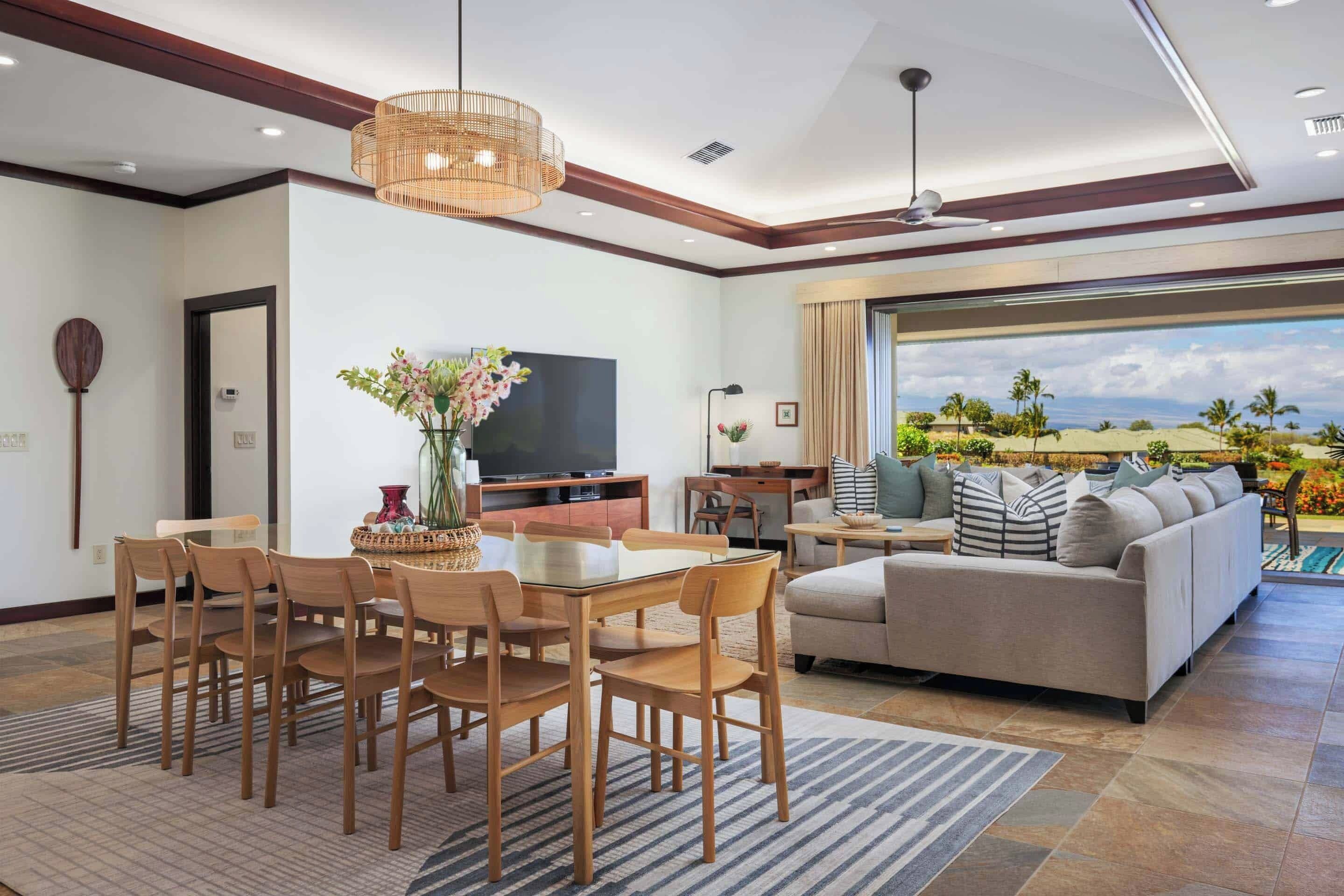 A modern living room with a dining area, a sofa, and a TV.