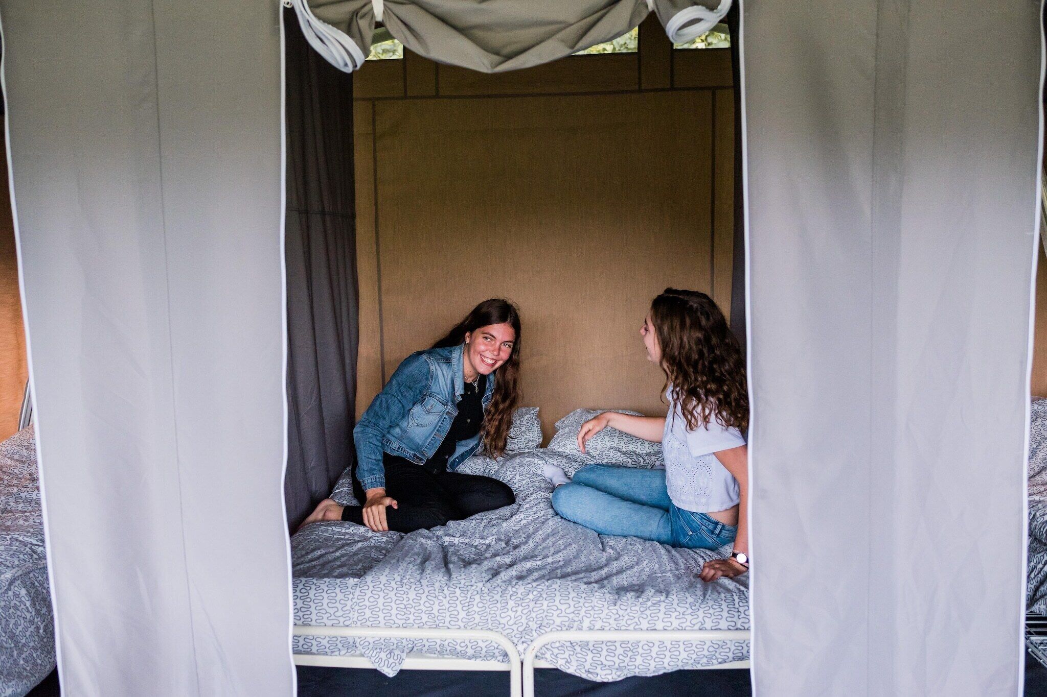 Un lit à baldaquin, une couvre-lit à motifs et une tête de lit.