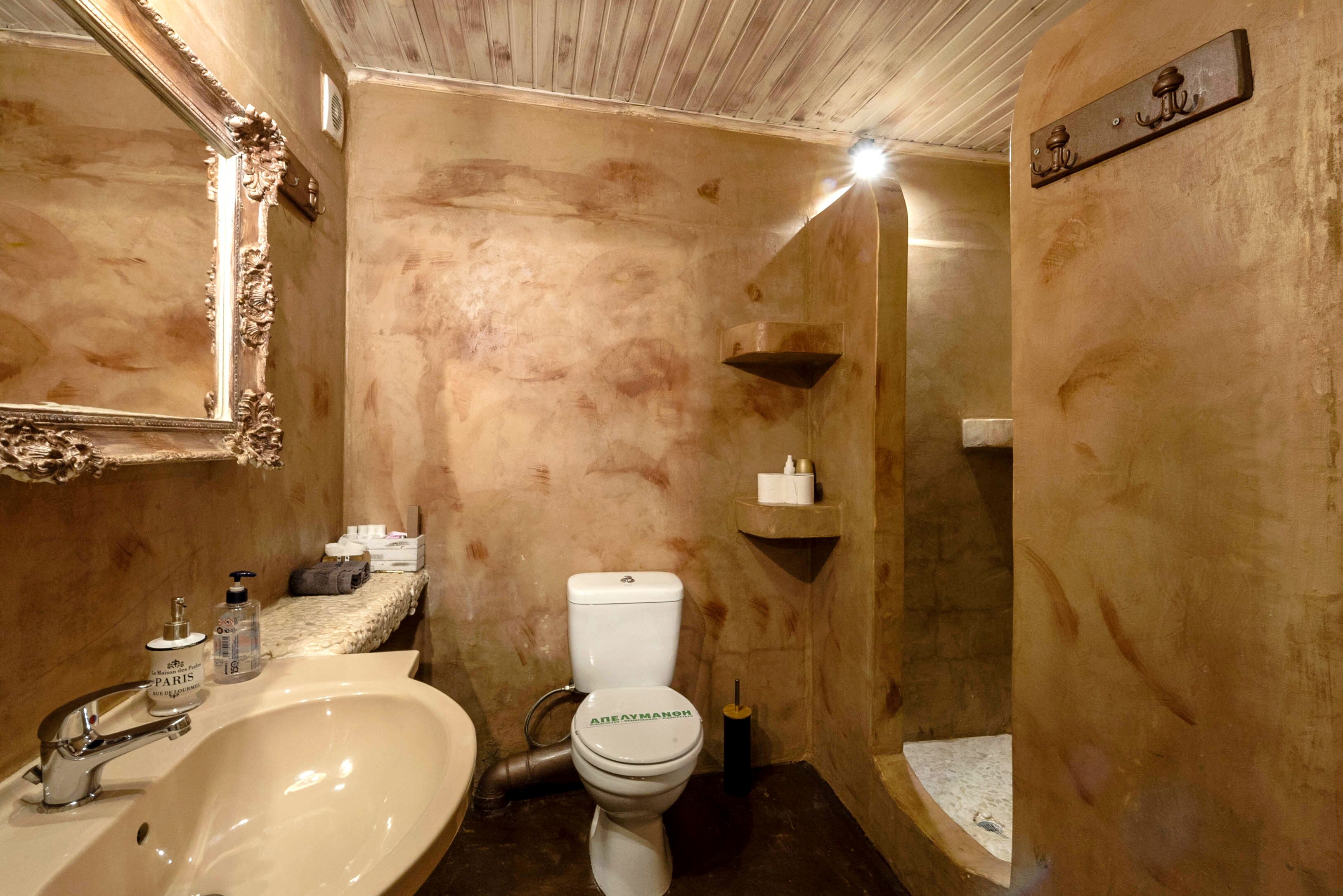A bathroom with a sink, toilet, and mirror.