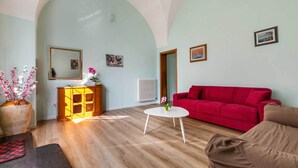 A living room with a red sofa, a white coffee table, and a wooden cabinet. - 3729 Pio Apartment by Barbarhouse (Lecce)